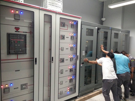 a group of people working on a large electrical panel