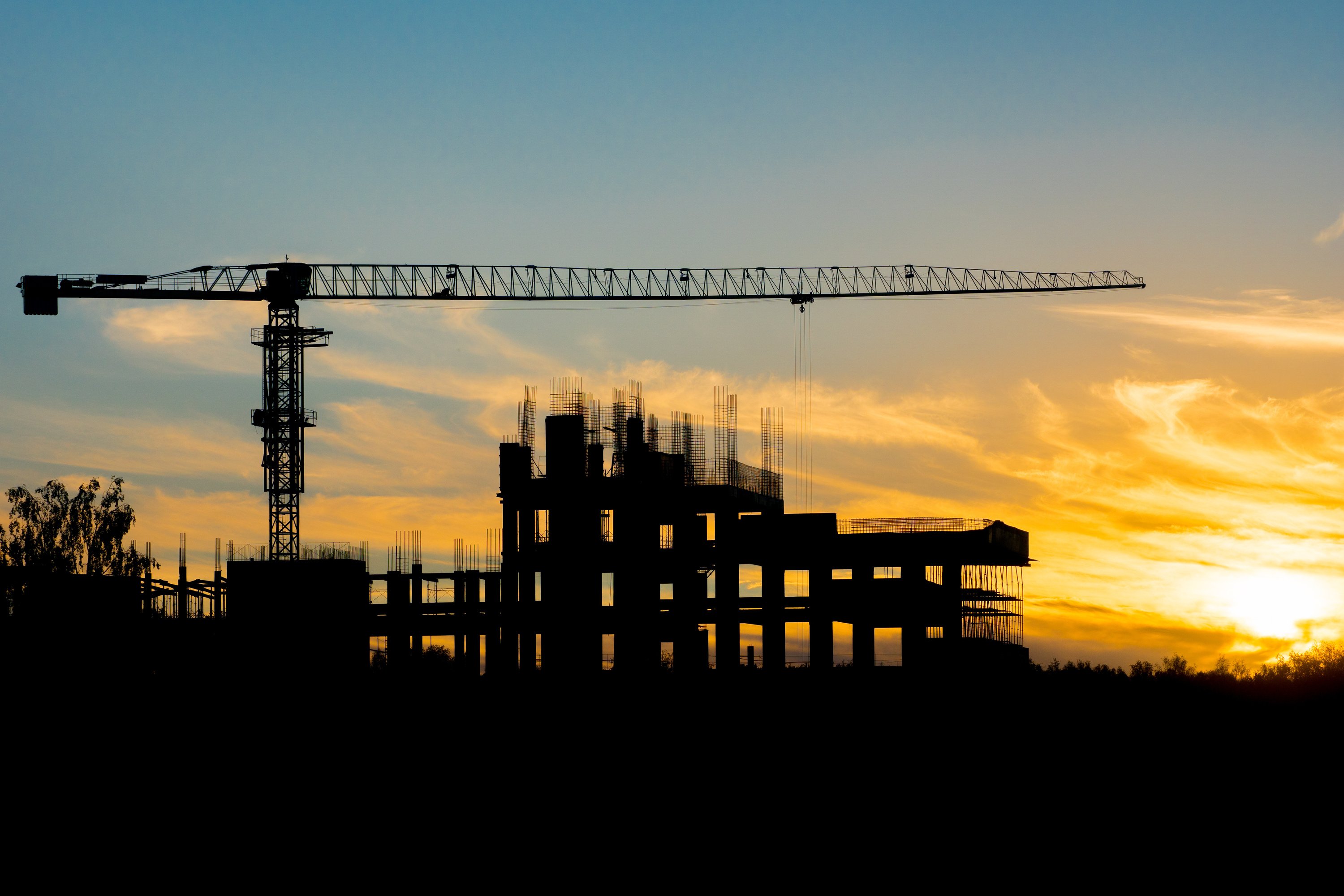 Construction Site and Crane on Sunset Background